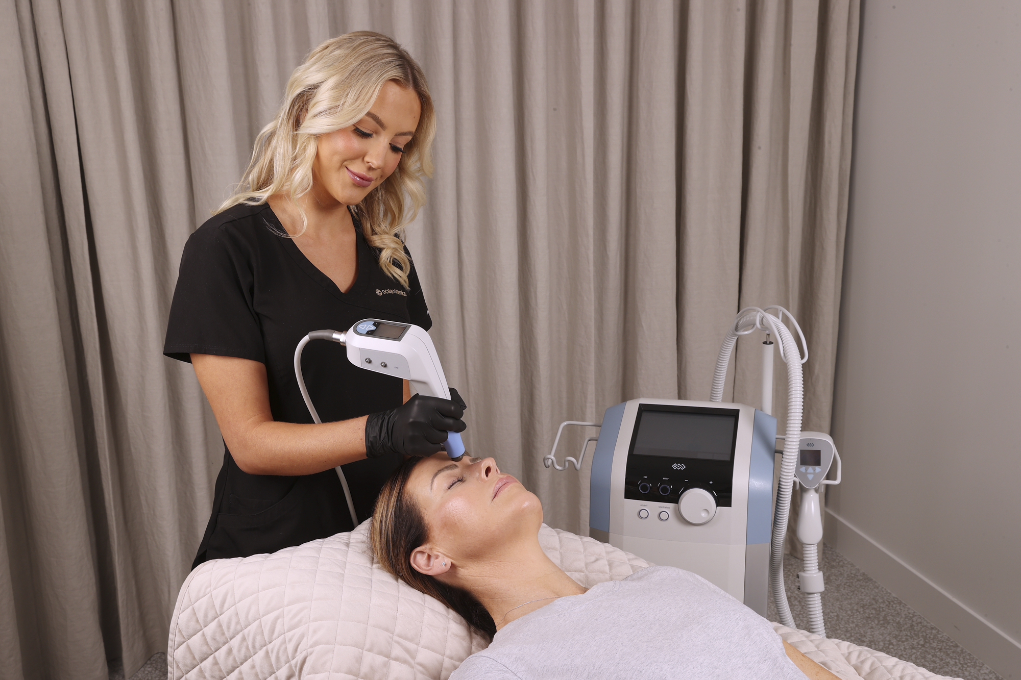 Woman receiving a facial treatment from a professional in a clinical setting.